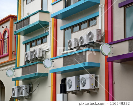 There are numerous air conditioners installed on the exterior of the building 116349222
