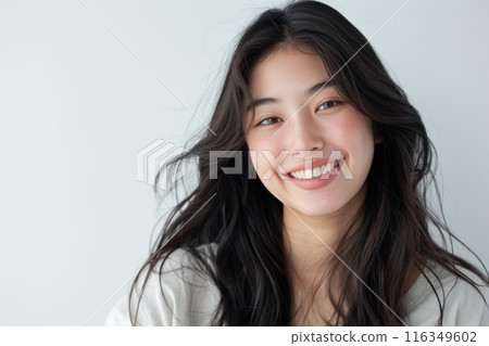 Asian woman with long hair is smiling and looking at the camera 116349602