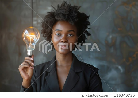 African American woman holding a light bulb in her hand African American woman holding a light bulb in her hand 116349739