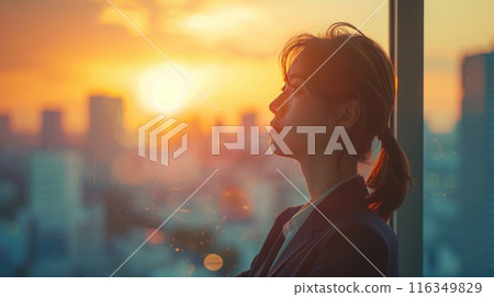 A woman is looking out of a window at the sun A woman is looking out of a window at the sun 116349829