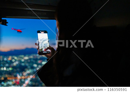 Young woman enjoying the night view on a surprise helicopter flight 116350591