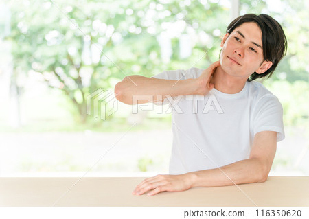 A young Asian man wearing a white T-shirt against a fresh green background 116350620