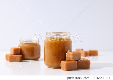 Cubes of salted caramel with caramel in a jar 116351084