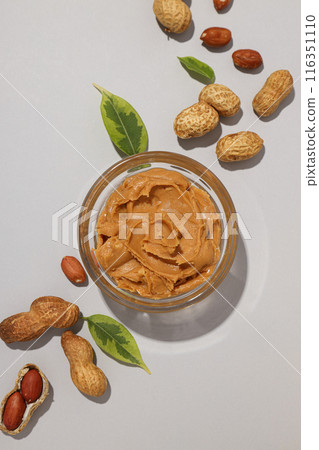 Peanut paste in a transparent plate, on a light background. Peanut paste in a transparent plate, on a light background. 116351110