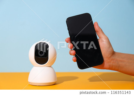 Surveillance camera with a smartphone on the table Surveillance camera with a smartphone on the table 116351143