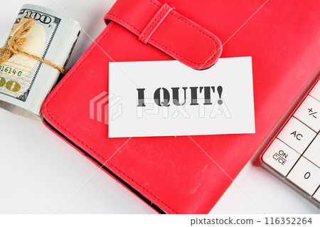 I Quit word on a business card on a red notebook with dollars and a calculator lying next to it 116352264