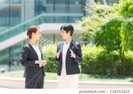 Career women standing in front of an office building 116353825