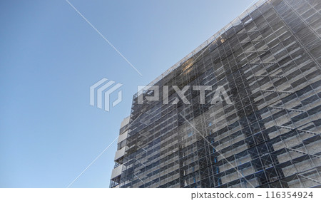 Scaffolding and blue sky at a building construction site 116354924