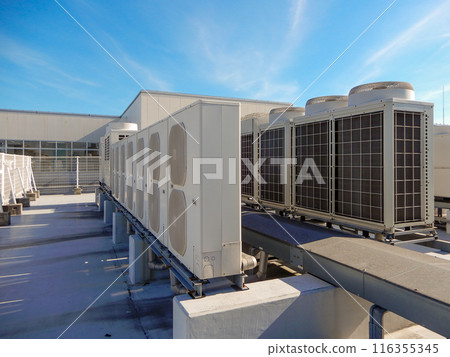 Outdoor unit of air conditioning facility on the roof of a building and blue sky Outdoor unit of air conditioning facility on the roof of a building and blue sky 116355345