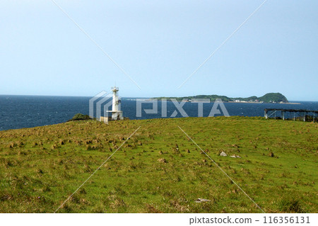 Yobuko, Karatsu City "Suginohara Pasture" on Kabe Island. A white lighthouse and the blue waters of the Genkai Sea. Yobuko, Karatsu City "Suginohara Pasture" on Kabe Island. A white lighthouse and the blue waters of the Genkai Sea. 116356131