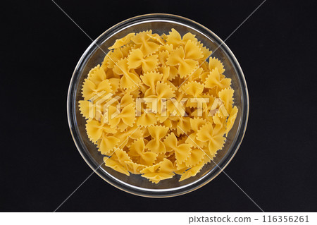 bowl of farfalle pasta on black background, top view bowl of farfalle pasta on black background, top view 116356261