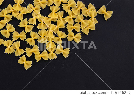 heap farfalle pasta on black background, top view heap farfalle pasta on black background, top view 116356262