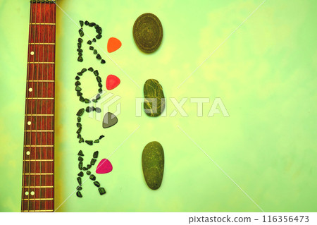 Fretboard of electric guitar with plectrums mediators.Rock on green yellow 116356473