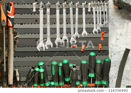 Wrenches,screwdrivers hang on a rack in a repair shop Wrenches,screwdrivers hang on a rack in a repair shop 116356493