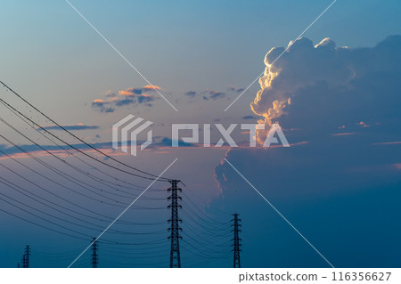 Evening cumulonimbus clouds rising above a power transmission tower a-1 Evening cumulonimbus clouds rising above a power transmission tower a-1 116356627