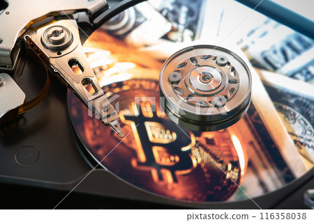 Inside of an open computer hard drive with the projected bitcoin symbol 116358038