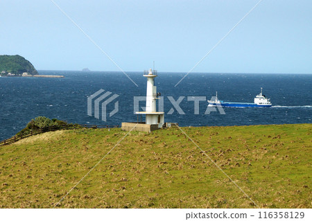 Yobuko, Karatsu City "Suginohara Pasture" on Kabe Island. A white lighthouse and the blue waters of the Genkai Sea. Yobuko, Karatsu City "Suginohara Pasture" on Kabe Island. A white lighthouse and the blue waters of the Genkai Sea. 116358129