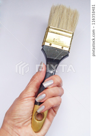 Paint brush in a woman's hand, repair. Paint brush in a woman's hand, repair. 116358481