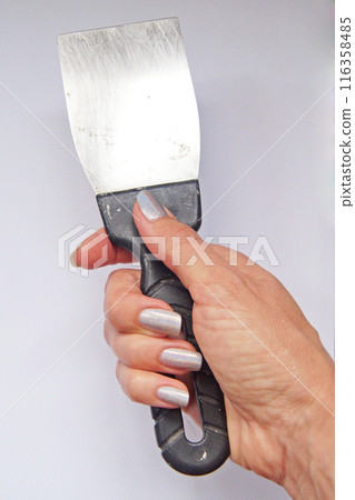 Spatula in a woman's hand, repair. Independent woman.        Spatula in a woman's hand, repair. Independent woman.        116358485
