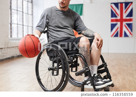 Cropped shot of young man with disability playing basketball in indoor court adaptive sports concept copy space 116358559