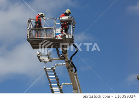 firefighters on a ladder in the middle of a rescue operation firefighters on a ladder in the middle of a rescue operation 116359324