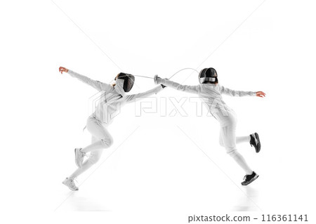 In preparation for match, two female fencers go head-to-head, each trying to outmaneuver other against white studio background. Movement. In preparation for match, two female fencers go head-to-head, each trying to outmaneuver other against white studio background. Movement. 116361141
