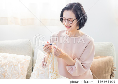Senior woman knitting in the living room Senior woman knitting in the living room 116361405