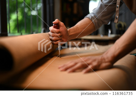 Cropped shot of young shoemaker cutting leather parts at table in his workshop studio 116361735