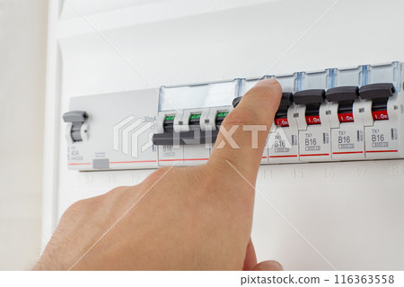 Hand Adjusting Circuit Breakers on Panel 116363558