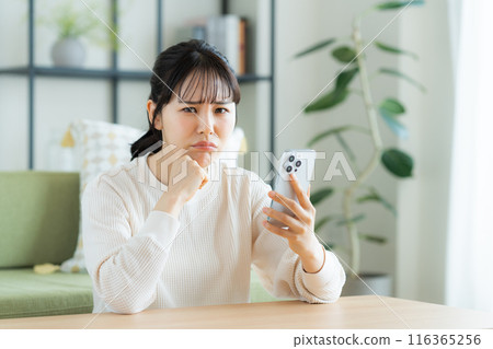 年輕女子在客廳看智慧型手機 116365256