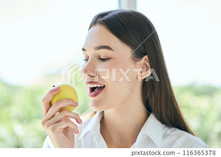 Dental Care. Young Woman Enjoying Fresh Apple Promoting Dental Health and Healthy Eating Dental Care. Young Woman Enjoying Fresh Apple Promoting Dental Health and Healthy Eating 116365378