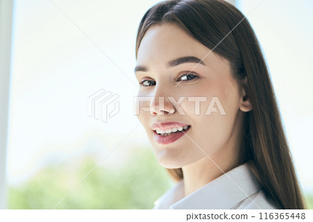 Smiling Young Woman With Long Hair Posing in Natural Light 116365448