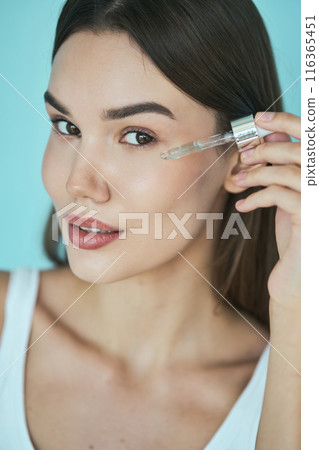 Skin Care Beauty. Woman Applying Facial Serum With Dropper for Glowing Healthy Skin 116365451