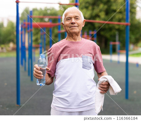 Elderly man standing on outdoor sports ground Elderly man standing on outdoor sports ground 116366184