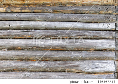 Old wooden wall made of gray pine tree logs with roman numerals 116367241