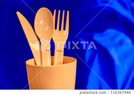 Camping.Pink plastic dinnerware set on blue.Cup,fork,knife,spoon Camping.Pink plastic dinnerware set on blue.Cup,fork,knife,spoon 116367466