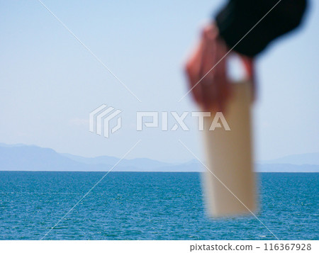 Person holding a water bottle in the sea Person holding a water bottle in the sea 116367928