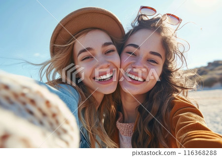 Two happy caucasian girls take a selfie outdoors on a sunny day. Smiling girlfriends take pictures on a mobile phone. Lifestyle. Close-up 116368288