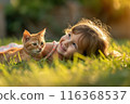 Happy little girl with ginger cat playing in green grass backyard. Having fun with your pet 116368537