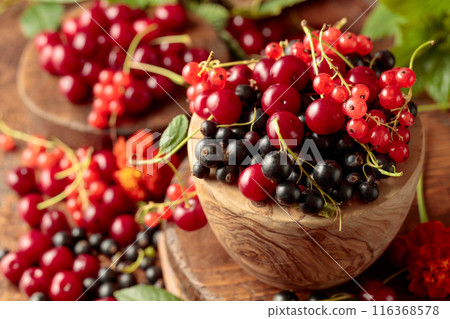 Cherries, red and black currants on the kitchen table. 116368578