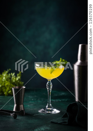Tropical yellow lemon cocktail on green background 116370199