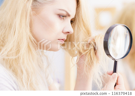 Woman magnifying her split ends hair 116370418