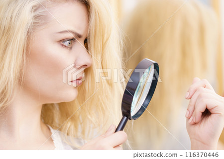 Woman magnifying her split ends hair Woman magnifying her split ends hair 116370446