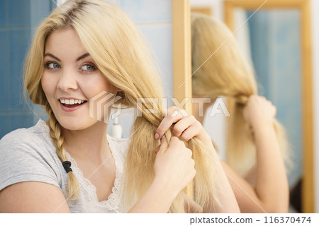 Woman making braid on blonde hair Woman making braid on blonde hair 116370474