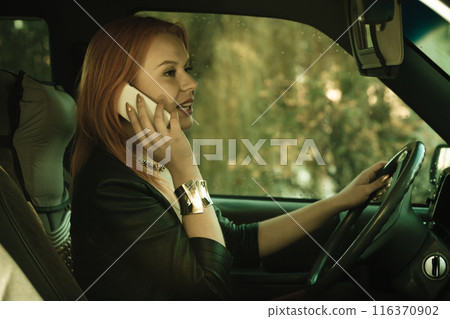 girl talking on mobile phone while driving the car. girl talking on mobile phone while driving the car. 116370902