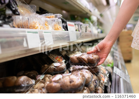 Woman's hand choosing shiitake mushrooms Woman's hand choosing shiitake mushrooms 116371460