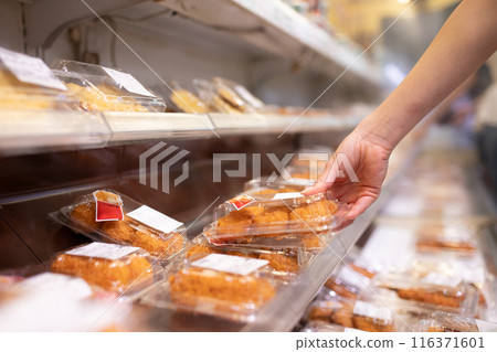 A woman's hand choosing a side dish 116371601