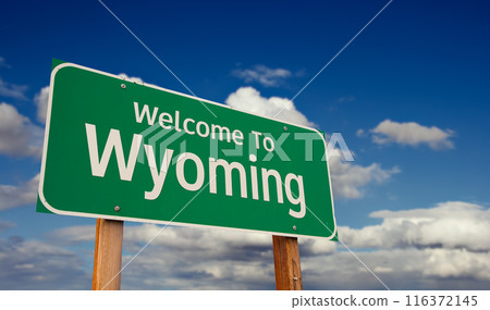 Welcome To Wyoming Green Road Sign Over Blue Sky with Some Clouds. 116372145