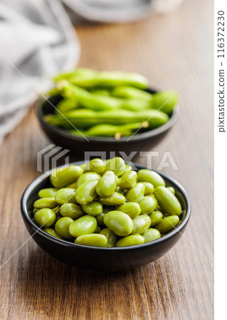 Edamame soy beans in bowl on wooden table. 116372230