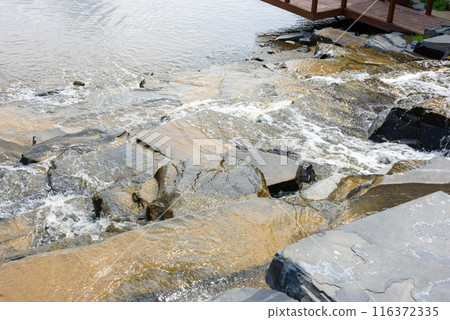 Top view of water flowing down the rocks of a cascading waterfall. Top view of water flowing down the rocks of a cascading waterfall. 116372335
